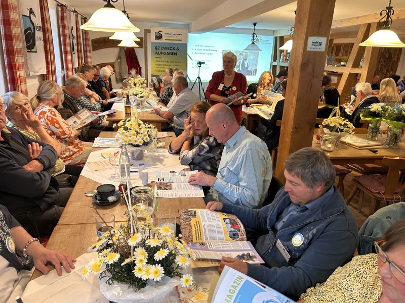 Die Vereinsmitglieder und Gäste der Jubiläumsfeier stöbern durch das druckfrische Vereinsmagazin